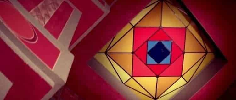 Looking up at a colorful stained glass skylight with geometric patterns