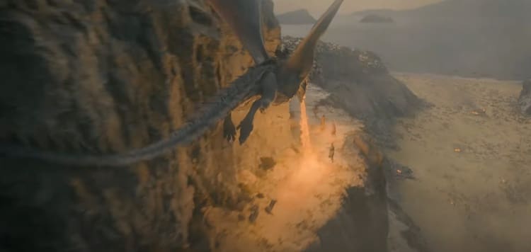 Overhead shot of the dragon Caraxes torching soldiers from above, the soldiers appearing to be traveling on a mountain pass.