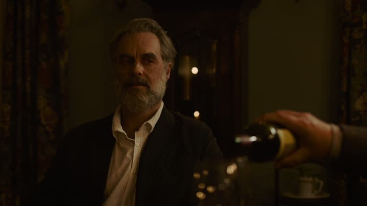 Frank, older, watches Bill pour a glass of wine