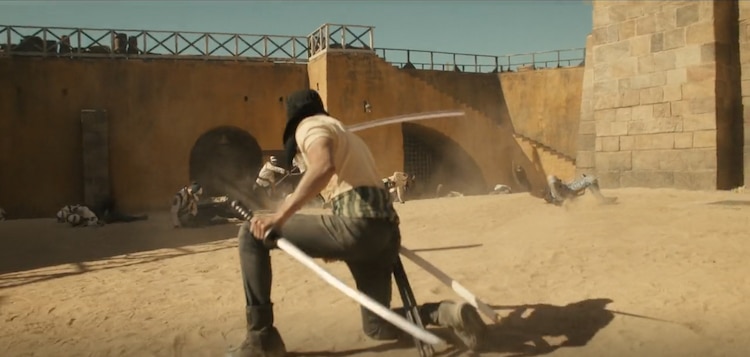 Zoro wields two swords. Marines are on the ground around him.