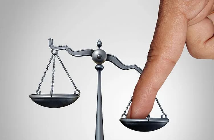 The right hand side of a grey balancing scale is being pushed down by a large finger